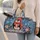 Penguin Holding a Gift in Winter Snow for Cozy Holiday Travel and Seasonal Getaways Quilted Weekend Bag - 2
